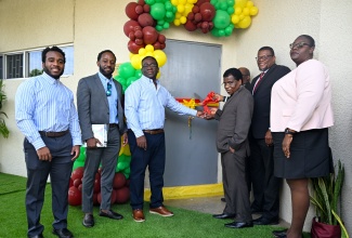 College of Agriculture, Science and Education (CASE) past student, Anthony Bogle (third left), and CASE President, Dr. Derrick Deslandes (second right), join in cutting the ribbon to mark the dedication, relaunch, and equipping of the Denna Bogle Computer Laboratory on March 19. Also pictured is Community Relations Education Officer for Region Two in the Ministry of Education, Skills, Youth and Information, Tanya Sinclair (right), among other stakeholders.