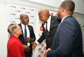 Director General, Planning Institute of Jamaica (PIOJ), Dr. Wayne Henry (second right), in conversation with Minister of Labour and Social Security, Hon. Pearnel Charles Jr. (second left); President of the Jamaica Red Cross Society (JRCS), Allasandra Chung (left), and Director General of the Office of Disaster Preparedness and Emergency Management (ODPEM), Commander Alvin Gayle. The interaction took place during the JRCS Hurricane Melissa Recovery Conference, held at the S Hotel in Kingston, on Tuesday (April 21).
