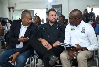 Minister of Agriculture, Fisheries and Mining, Hon. Floyd Green (left), makes a point to Chief Executive Officer of the Rural Agricultural Development Authority (RADA), Garnet Edmondson (right), at the official launch of Isratech’s Resilience Farm Tour, held at the company’s Manchester offices in Kendal, on April 8. At centre is Chief Executive Officer of the company, Benjamin Hodara.
