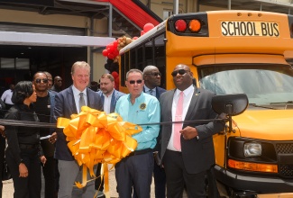 Energy, Transport and Telecommunications Minister, Hon. Daryl Vaz (second right), prepares to cut the ribbon to open the School Bus Operations Centre (SBOC) for the Rural School Bus Programme, at 26 Lyndhurst Road in Kingston on Wednesday (April 15). He is joined by (from left) Chief Executive Officer of Elhydro, which is the entity managing the programme, Tanya Morgan; Chargé d’Affaires, United States Embassy in Kingston, Scott Renner; and Parliamentary Secretary in the Ministry of Education, Skills, Youth and Information, Senator Marlon Morgan.
