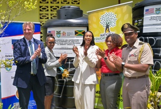 Minister of State in the Ministry of Education, Skills, Youth and Information, Hon. Rhoda Moy Crawford (third left), along with (from left)  United States Chargé d’Affaires to Jamaica, Scott Renner; Principal of Bethany Primary, Prudence Bennett-Blake; Executive Director of the National Education Trust (NET), Latoya Harris-Ghartey, and Senior Defence Officer attached to the United States (US) Southern Command Humanitarian Assistance Programme, Lieutenant Angel Lopez Jr., celebrate the official handover of two 1,000-gallon tanks to the Bethany Primary School in Manchester, on April 22.
