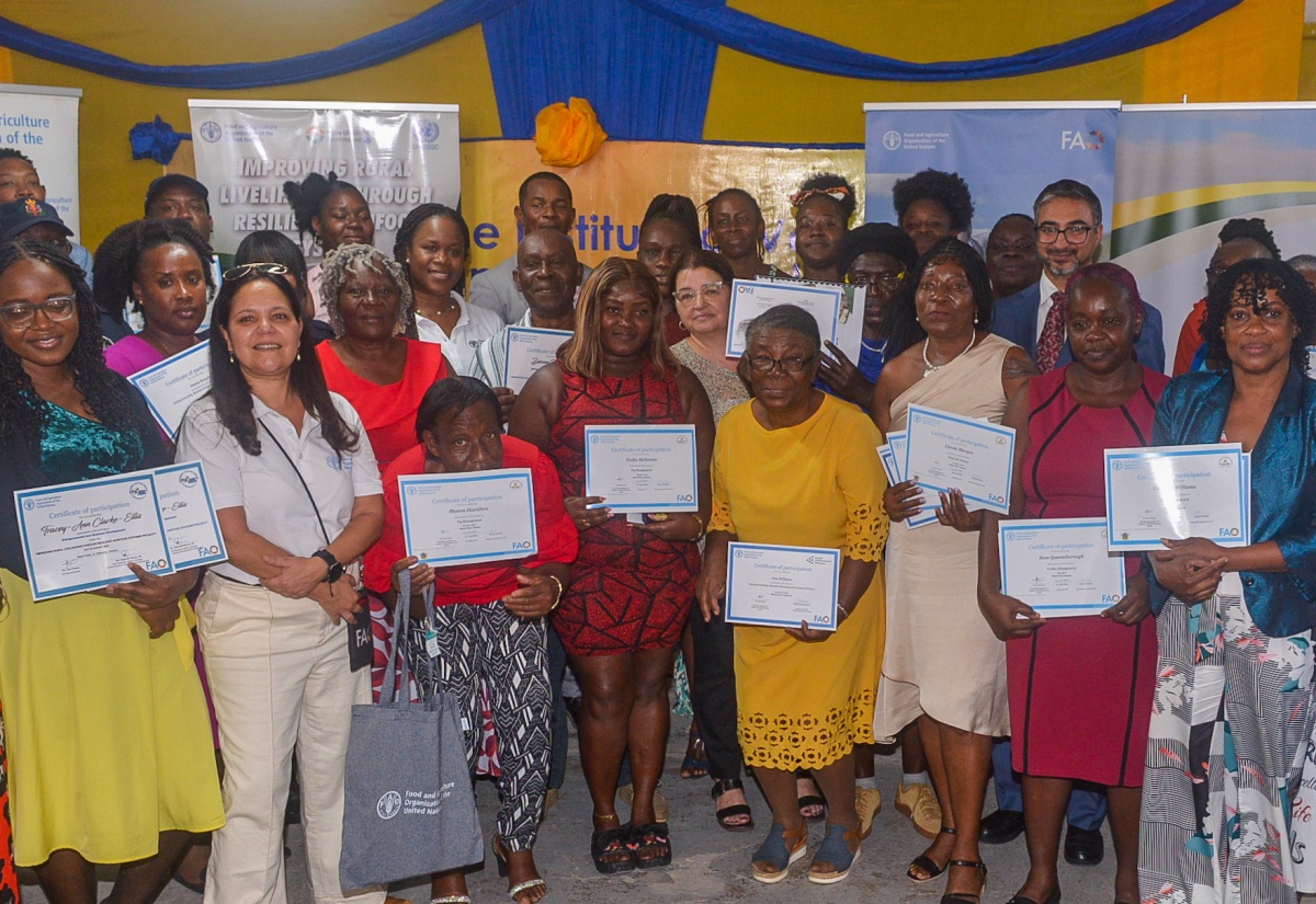Participants in the Improving Rural Livelihoods through Resilient Agri-food Systems (IRL) Project, in the company of officials, display their certificates during the certification ceremony, held recently at the Spring Village Community Centre in St. Catherine.
