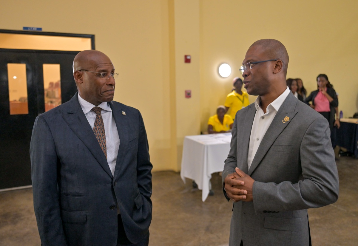 Minister of Industry, Investment and Commerce, Hon. Aubyn Hill (left), engages in conversation with President, University of Technology (UTech), Dr. Kevin Brown, just before the start of the Technology Innovation Centre (TIC) Know Your Numbers Competition held at the UTech campus in St. Andrew on Monday (April 20). 
