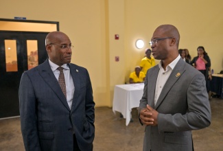 Minister of Industry, Investment and Commerce, Hon. Aubyn Hill (left), engages in conversation with President, University of Technology (UTech), Dr. Kevin Brown, just before the start of the Technology Innovation Centre (TIC) Know Your Numbers Competition held at the UTech campus in St. Andrew on Monday (April 20). 
