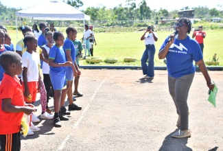 Regional Health Promotion and Education Officer at the Western Regional Health Authority (WRHA), Marceleen Wheatle (right), engages with students of Bounty Hall Primary and Infant School in Trelawny during National School Moves Day activities at the institution on April 24.