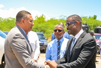 Prime Minister, Dr. the Most Hon. Andrew Holness (left), is greeted by President of the Central Jamaica Conference of Seventh-day Adventists, Pastor Nevail Barrett, ahead of the start of Saturday's (April 25) Youth Empowerment Series (SDA Y.E.S.) Sabbath worship service in Portmore, St. Catherine, held under the theme: 'Proclamations of Hope'. At centre is Marshal of the Houses of Parliament, Wayne Blake.