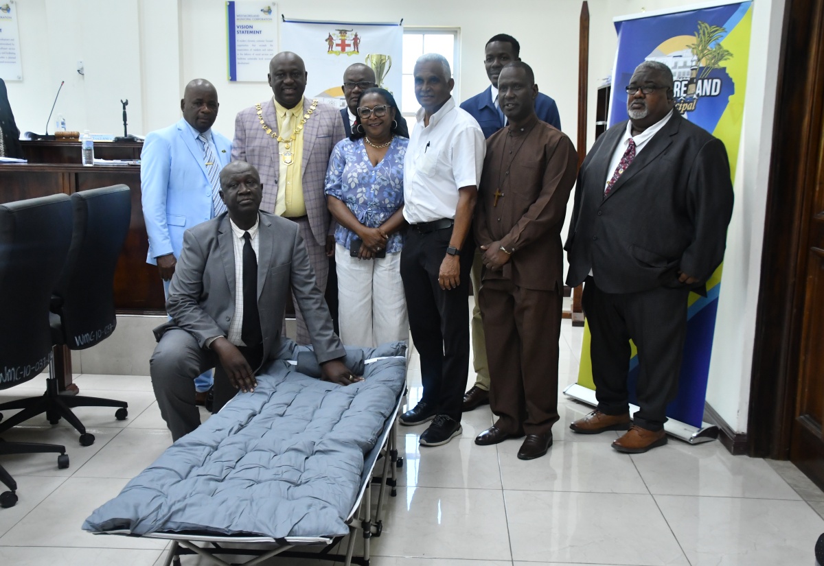 Mayor of Savanna-la-Mar, Councillor Danree Delancy (standing, second left, front row), and Councillors of the Westmoreland Municipal Corporation, share a moment with Director of the Lake Group of Companies, Michael Lake (third right, front row). The occasion was the Corporation’s monthly meeting on April 9, during which Mr. Lake presented 150 cots to bolster emergency response in the parish.
