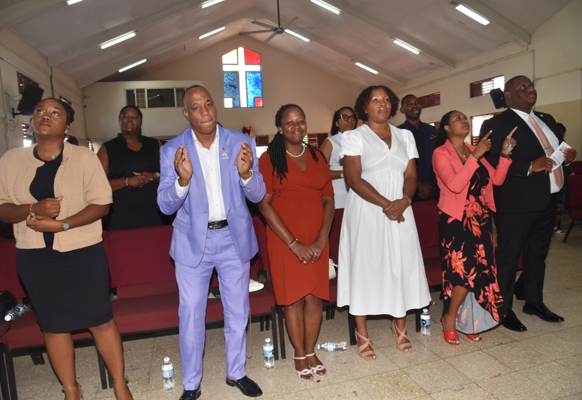 Parliamentary Secretary in the Ministry of Education, Skills, Youth and Information, Senator Marlon Morgan (right), participates in the 16th anniversary Church Service of the National Education Trust (NET), held earlier this year at the Christian Fellowship World Outreach in Kingston. He is joined by staff from NET.
