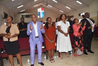 Parliamentary Secretary in the Ministry of Education, Skills, Youth and Information, Senator Marlon Morgan (right), participates in the 16th anniversary Church Service of the National Education Trust (NET), held earlier this year at the Christian Fellowship World Outreach in Kingston. He is joined by staff from NET.