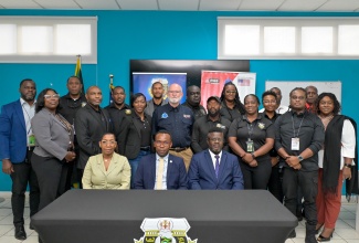 Team Lead, Container Security Initiative International Field Office Jamaica, United States Customs and Border Protection, Charlene McFarlene (seated left),  Assistant Director for Policy Strategy and Innovation, Caribbean Community Implementation Agency for Crime and Security (CARICOM IMPACS), Callixtus Joseph (seated center) and Deputy Chief Executive Officer, Border Protection Division, Jamaica Customs Agency’s (JCA), Marlon Lowe (seated right) with graduates and other stakeholders during the Weapons and Ammunition Management Training Course Graduation Ceremony held on Friday (May 8) at the Jamaica Customs Agency’s (JCA) Training Branch at the Jamaica Foreign Trade Zone (JFIZ) Building in Kingston.