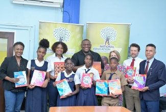 Parliamentary Secretary in the Ministry of Education, Skills, Youth and Information, Senator the Hon. Marlon Morgan (third left, back row), shares a photo opportunity with education stakeholders, donors, and students of Broadleaf Primary School in Manchester during the official handover ceremony on Friday (May 15), at the National Education Trust (NET), Caenwood Centre, Kingston. The event marked the donation of books by Macmillan Education in partnership with Kingston Bookshop to institutions affected by Hurricane Melissa. Pictured (from left, back row) are Director of Strategy and Innovation at Kingston Bookshop, Shauna Fuller-Clarke; NET Executive Director, Latoya Harris-Ghartey; Caribbean Sales Manager at Macmillan Education, Deborah Brearley; Schools Publisher at Macmillan Education, James Orr; and Principal of Broadleaf Primary School, Eaton McNamee.