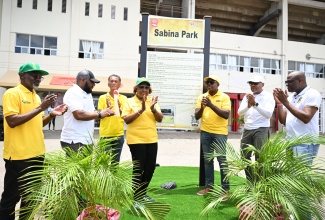 Minister of Culture, Gender, Entertainment and Sport, Hon. Olivia Grange (centre), applauds after unveiling a newly designed storyboard illustrating the history of Sabina Park as part of the National Labour Day Project being undertaken at the site. Joining her (from left) are Permanent Secretary in the Ministry, Denzil Thorpe; Executive Director of the Jamaica National Heritage Trust (JNHT), Dr. Leslie Harrow; President of the Jamaica Cricket Association (JCA), Dr. Donovan Bennett; Minister of Labour and Social Security, Hon. Pearnel Charles Jr.; Chief Executive Officer of the Kingston and St. Andrew Municipal Corporation (KSAMC), Robert Hill; and former Jamaican cricketer, Nehemiah Perry.
