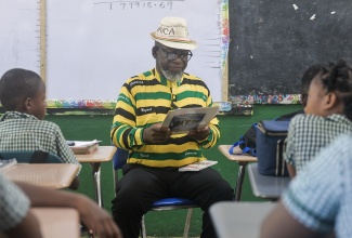 Senior Reporter at the Jamaica Information Service (JIS), Garfield Angus, reads to students of Paul Mountain Primary School in St. Catherine in observance of Read Across Jamaica Day on Tuesday (May 5). The activity forms part of Education Week 2026, being observed from May 3 to 9 under the theme ‘Literacy Resilience: Foundation to Nation Building’.
