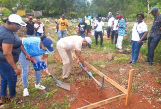 Chairman of the St. Catherine Municipal Corporation and Mayor of Spanish Town,  Councillor Norman Scott (right), along with Parish Manager at the Social Development Commission (SDC), Shana-Lee Archibald (centre), break ground for the construction  of  sanitary facilities at the Barry and Lloyd Cemetery in Kitson Town, St. Catherine on Monday (May 25). Looking on at left is Chief Executive Officer (CEO) of the St. Catherine Municipal Corporation, Marvalyn Pitter. The cemetery was the St. Catherine Parish Project for Labour Day 2026. 