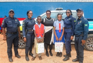 Station Manager at the Guanaboa Vale Police Station, Sergeant Navelette Davis-Leachman (second right), celebrates with Child Month awardees at the Kitson Town Primary School, in St. Catherine, Sage Dennis (third left), Tisha-Lee Whittle (third right), during an event held at the school. Others (from left) are Constable Ralston McCalla,  Constable Shaniek Johnson, Principal of the school, Dr. Donna Mitchell-Jarrett, and Constable Richardo Thompson.