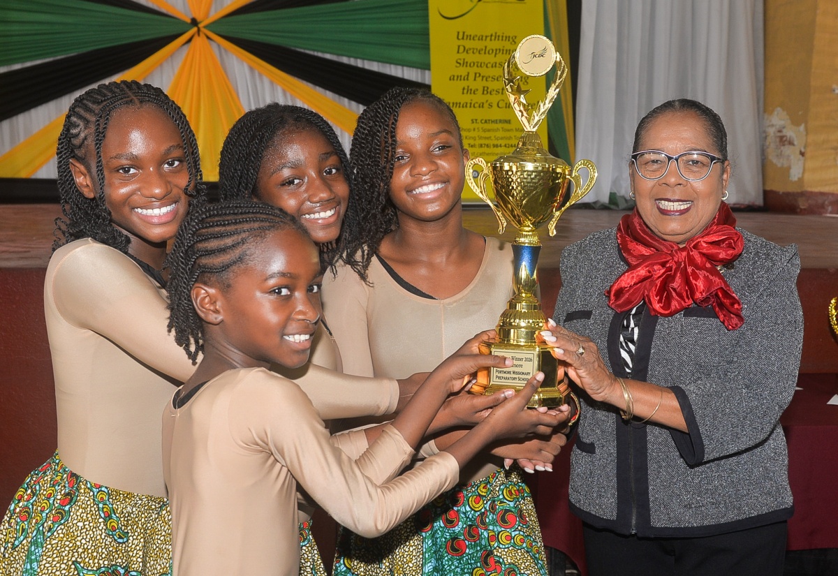 Custos of St. Catherine, Hon. Icylin M. Golding (right), presents a trophy to students from the Portmore Missionary Preparatory and Kindergarten School, for winning the third place prize in the Jamaica Cultural Development Commission (JCDC) Eastern Region annual Festival of the Performing Arts, which they shared with the Old Harbour High School. They were presented with the award during a ceremony held at the St. Jago Cathedral Church hall on May 7, in Spanish Town, St. Catherine.