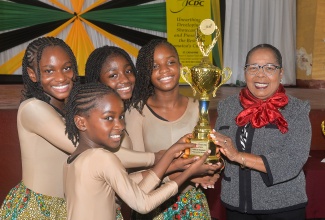 Custos of St. Catherine, Hon. Icylin M. Golding (right), presents a trophy to students from the Portmore Missionary Preparatory and Kindergarten School, for winning the third place prize in the Jamaica Cultural Development Commission (JCDC) Eastern Region annual Festival of the Performing Arts, which they shared with the Old Harbour High School. They were presented with the award during a ceremony held at the St. Jago Cathedral Church hall on May 7, in Spanish Town, St. Catherine.