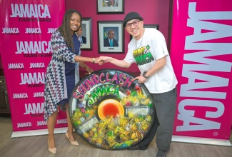 Commissioner General of Section, Jamaica Pavilion at Expo 2025 Osaka, Maureen Smith, gifts Masta Simon of Japanese Sound System, Mighty Crown, a piece of artwork taken from the Jamaica Pavilion at Expo 2025. The presentation was made on May 14 at the Jamaica Tourist Board (JTB) offices in New Kingston. The artwork depicts the showdown between Bass Odyssey and Mighty Crown at the World Sound Clash held in Jamaica in 2007. The Jamaica Pavilion was titled ‘Out of Many, One People: Let’s Link Up’ to life.