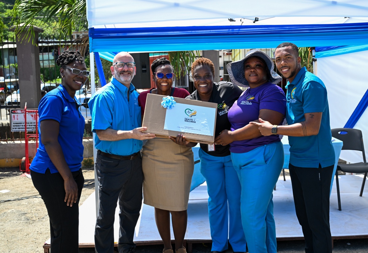 Pan American Health Organization (PAHO)/World Health Organization (WHO) representative to Jamaica, Bermuda and the Cayman Islands, Ian Stein (second left); and Acting Director, Family Health Unit in the Ministry of Health & Wellness, Julia Rowe-Porter (left), present the Port Maria Health District with their prize for winning the HPV jingle competition during a Vaccination Drive and Health Fair in Port Maria, St. Mary, on April 30.