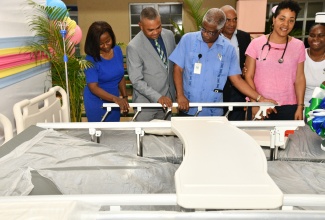 Chairman of the Southern Regional Health Authority (SRHA), Michael Stern (second left), examines one of the 20 paediatric beds donated to the Mandeville Regional Hospital in Manchester by bauxite and alumina company, Jamalco. The beds were formally handed over during a ceremony at the hospital on May 14. Also pictured (from left) are the hospital’s Paediatric Consultant, Dr. Jacqueline Dunkley Thompson; Senior Medical Officer, Dr. Everton McIntosh; Management Committee Chairman, John O. Minott; and Paediatric Consultant, Dr. Shani Fletcher Groves.
