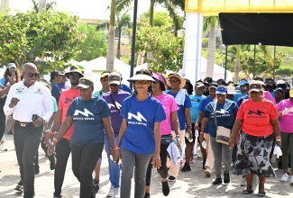 Minister of Labour and Social Security, Hon. Pearnel Charles Jr. (left), joins senior citizens in a walking exercise during the launch of the Park Walker Initiative at Harmony Beach Park in Montego Bay, St. James, on Friday (May 29).