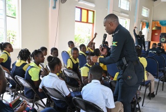 Chairperson, Sergeant Andrew Williams of the Jamaica Constabulary Force (JCF) Community Safety and Security Branch (CSSB) interacts with students from Morant Bay Primary School in St. Thomas during the launch of the