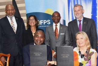 State Minister in the Ministry of Finance and the Public Service, Hon. Zavia Mayne (left, seated), and Ambassador of the European Union (EU) to Jamaica, Her Excellency Dr. Erja Askola (right, seated), exchange signed agreements for the implementation of the Digital Transitioning Programme for Jamaica (Digital Jamaica) during a Handover Ceremony at the Ministry’s office in Kingston on Thursday (May 21). Sharing the moment are (from left) Director General for the Planning Institute of Jamaica (PIOJ), Dr. Wayne Henry; Permanent Secretary in the Ministry of Industry, Investment and Commerce, Sancia Bennett Templer; Permanent Secretary in the Office of the Prime Minister, Ambassador Dr. Rocky Meade; and Ambassador of the Federal Republic of Germany to Jamaica, His Excellency Jan Hendrik van Thiel.