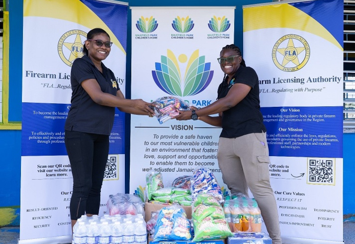 Kimberlee Solomon (left), Director of Corporate Planning and Client Relations at the Firearm Licensing Authority (FLA), presents items to Nellisa Asphall, Assistant Manager of the Maxfield Park Children’s Home, on Labour Day, May 25. The presentation and the repainting of the home