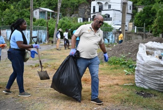 Social Development Commission (SDC) St. Mary Parish Manager, Shawin Reynolds, participates in Labour Day clean-up activities at Clembhard’s Park in Port Maria, on Monday (May 25).
