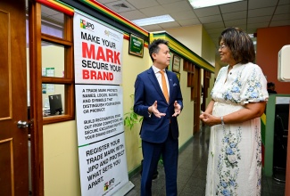 Executive Director, Jamaica Intellectual Property Office (JIPO), Lilyclaire Bellamy explaining procedures of the JIPO to Director General of the United Nations World Intellectual Property Organization (WIPO), Daren Tang, during a tour of the JIPO offices in Kingston on Monday (May 18).  
