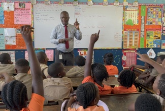 Director of Corporate Services, Jamaica Information Service (JIS), Errol Gardner, engages in an interactive session with students at Edward Seaga Primary School in Denham Town, Kingston, during Read Across Jamaica Day at the institution on Tuesday (May 5). The day, which is observed annually during Education Week, is aimed at promoting a strong culture of reading, fostering a national love for literacy among children and youth, and highlighting literacy as a crucial foundation for both personal growth and national development.
