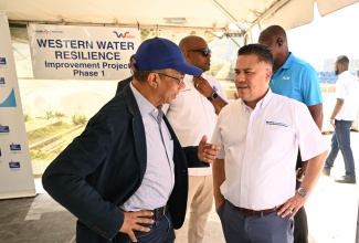 Deputy Prime Minister and Minister of National Security and Peace, Hon. Dr. Horace Chang (left), interacts with Minister of Water, Environment and Climate Change, Hon. Matthew Samuda, during the viewing of pipes ceremony for phase one of the Western Water Resilience Project, at a site in Freeport, St. James, on Wednesday (April 29).
