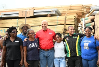 Minister of Agriculture, Fisheries and Mining, Hon. Floyd Green (second right), shares a moment with beneficiaries under the Comeback Coops initiative in Parottee, St. Elizabeth on Friday (May 1). He is joined by Founder and Executive Director of Not in Vain Foundation (NIV), Bridgette Barrett (left); and Vice President of Hi-Pro, Colonel (ret’d) Jaimie Ogilvie (centre).