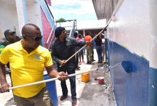 Mayor of Kingston, Councillor Andrew Swaby (left), and President of the Universal Negro Improvement Association (UNIA) and African Communities League, Stephen Golding, join forces to paint a wall during the Kingston and St. Andrew Municipal Corporation’s (KSAMC) Labour Day activities at Franklin Town Primary School in Kingston on Monday (May 25). The KSAMC carried out work at three project sites: Franklin Town Primary School, the St. William Grant Monument in Brandon Hill, and Liberty Hall in downtown Kingston.
