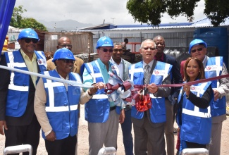 Taking part in the ribbon-cutting exercise at the ground-breaking ceremony for the US$25-million SANA commercial development are (from left) Chairman of the Money Masters Real Estate and Infrastructure Investments Limited, Michael McNaughton; Chairman of Money Masters-REIF South Development Ltd, Ewan Straw; Science, Energy, Telecommunications and Transport Minister, Hon. Daryl Vaz; former Prime Minister, Bruce Golding; President of Money Masters Ltd, Claudette Crooks; and Justice Minister, Hon. Delroy Chuck. The ceremony was held on Thursday (May 28) at the South Avenue site in Kingston.