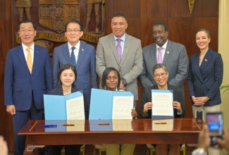 Prime Minister, Dr. the Most Hon. Andrew Holness (centre, standing), participates in the signing ceremony for the Land Administration Capacity Enhancement Project (LACEP) at Jamaica House on Tuesday (May 12). He is joined by (from left), President and Chief Executive Officer (CEO) of Korea Land and Geospatial Informatix Corporation, Myeongso Eo; Charge d