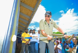 Prime Minister, Dr. the Most Hon. Andrew Holness, paints a section of the Lewis Town Early Childhood Institution (ECI) in Brompton, St. Elizabeth, during National Labour Day activities at the school on Monday (May 25).