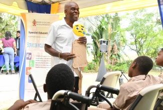 Visually impaired instructor, Dr. Hixwell Douglas, guides a session with special needs students at the Ministry of Education, Skills, Youth and Information