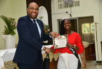 Minister of State, Ministry of Industry, Investment and Commerce, Hon. Delano Seiveright (left), presents a certificate to St. Richard