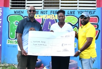 Chief Executive Officer of the Coconut Industry Board (CIB), Shaun Cameron (right), and representative of the Croydon, United Kingdom (UK)-based volunteer group,  Dr Andrew Brown, present a cheque to Principal of Unity Primary in Strathbogie, Westmoreland, Dawnette Hall-Beharie, on Tuesday (April 28), in support of post-Hurricane Melissa relief efforts.

