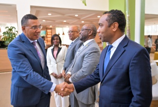 Prime Minister, Dr. the Most Hon. Andrew Holness (left), greets Urban Development Corporation (UDC) General Manager, L. Robert Honeyghan, at the agency’s Board Meeting, held on Thursday (April 30) at Courtyard by Marriott Kingston. Also attending are (from second left) Permanent Secretary in the Ministry of Economic Growth and Infrastructure Development, Arlene Williams; UDC Chairman, Norman Brown, and Deputy Chairman, Robert Lawrence.
