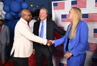 Minister of Tourism, Hon. Edmund Bartlett (left), is greeted by Hilary Renner (right), wife of the Chargé d’Affaires, Embassy of the United States (US), Scott Renner (centre), at the US Independence Day celebrations on June 24, at the Embassy in Kingston. On July 4, the US will commemorate 250 years since the signing of the Declaration of Independence.
