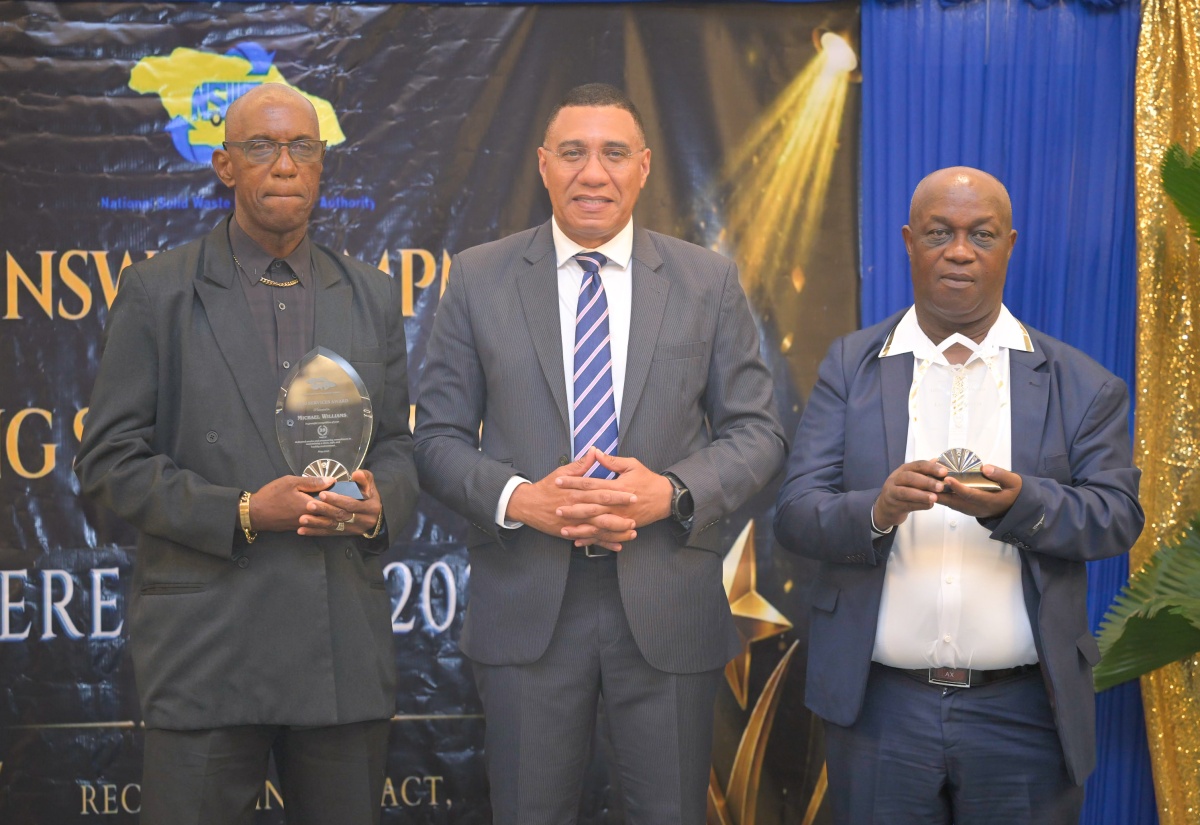 Prime Minister, Dr. the Most. Hon. Andrew Holness (centre), shares a photo opportunity with National Solid Waste Management Authority (NSWMA) employees (from left) Michael Williams and L. Francis, during the NSWMA Long-Service Awards Ceremony, held at AC Hotel in Kingston on Thursday (June 4).
