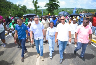  Prime Minister, Dr. the Most Hon. Andrew Holness (second right), is joined by (from left) Minister without Portfolio in the Ministry of Economic Growth and Infrastructure Development with responsibility for Works, Hon. Robert Morgan; Permanent Secretary in the Ministry, Arlene Williams; Member of Parliament for Manchester North Western, Mikael Phillips; along with stakeholders and community members, as they cross the new $230 million Troy Bridge, officially opened on Friday (June 5).
