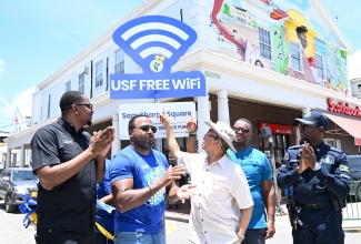 Minister of National Security, Hon. Dr. Horace Chang (centre), is joined by (from left) Councillor for the Cambridge Division, Javin Baker; Chief Executive Officer of the Universal Service Fund (USF), Charlton McFarlane; Deputy Speaker of the House of Representatives, Heroy Clarke; and Commanding Officer for the St. James Police Division, Senior Superintendent of Police (SSP) Eron Samuels, in officially unveiling the USF Free Wi-Fi signage to mark the restoration of free public Wi-Fi service during the Connec’ Di West Road Tour at Sam Sharpe Square in Montego Bay on Friday, June 19.