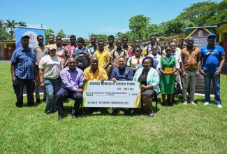 Minister of State in the Ministry of Labour and Social Security, Hon. Donovan Williams (second right, seated) and, (from left, seated) Supervisor at Gebbers Farms in the United States, Eyon Gayle; Director of the Overseas Employment Services Centre, Delroy Palmer; and Wycliffe Martin High School Principal, Evorine Henry-Tracey are photographed with agricultural students from high schools across St. Mary and workers of Gebbers Farms. The occasion was the presentation of $600,000 in academic grant support by the workers for the students on June 5 at Wycliffe Martin High School in St. Mary. 
