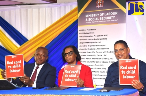 Minister of Labour and Social Security, Hon. Pearnel Charles Jr. (left), is joined by Acting Permanent Secretary in the Ministry, Dione Jennings (centre), and State Minister, Hon. Donovan Williams, in displaying the ‘Red Card to Child Labour’ during the Ministry’s World Day Against Child Labour Jingle Competition awards ceremony at the Jamaica Conference Centre in downtown Kingston on Friday (June 12).
