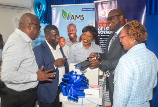 Head of the Urology Department at the Spanish Town Hospital, Dr. Elon Thompson (second right), celebrates the handover of three pieces of medical equipment, including an ultrasound machine, which he donated to the institution, today (June 16). Others pictured (from left) are Parish Manager, St Catherine Health Services, Abdon Campbell; Chief Executive Officer of the National Health Fund (NHF), Everton Anderson; Senior Medical Officer at the Spanish Town Hospital, Dr. Jacqueline Wright-James, and Chief Executive Officer of the hospital, Jacqueline Ellis.
