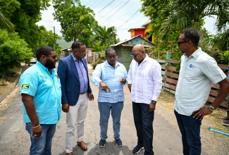 Minister without Portfolio in the Ministry of Economic Growth and Infrastructure Development with responsibility for Land Titling and Settlement and Member of Parliament for St. Mary Western, Hon. Robert Montague (centre), converses with Tourism Minister, Hon. Edmund Bartlett (second right), during a recent ceremony marking the symbolic opening of the rehabilitated Fontabelle to Geddes Town Road in St. Mary. Listening are (from left) Managing Director of Wadmar Construction Limited, Mark Knight; Mayor of Port Maria, Councillor Fitzroy Wilson; and Executive Director of the Tourism Enhancement Fund (TEF), Dr. Carey Wallace.
