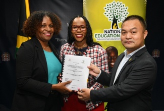 Permanent Secretary, Ministry of Education, Skills, Youth and Information, Dr. Kasan Troupe (centre), is joined by Executive Director, National Education Trust (NET), Latoya Harris Ghartey (left), and Managing Director, China Civil Engineering Construction Corporation, Jay Wang, in displaying the signed contract for Jamaica